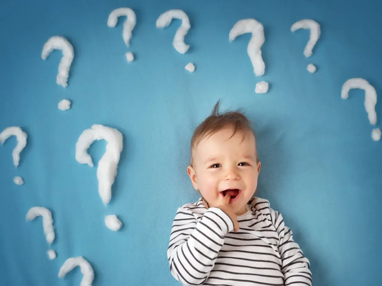 Un neonato sorridente con tante domande intorno. Quante volte fa la cacca un neonato di 1 mese?