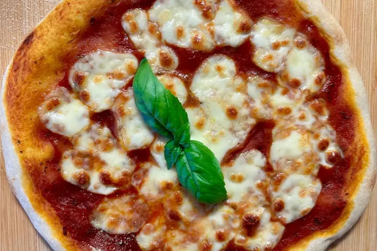 Eine köstliche italienische Sauerteig Pizza Margherita mit geschmolzenem Mozzarella und frischem Basilikum.