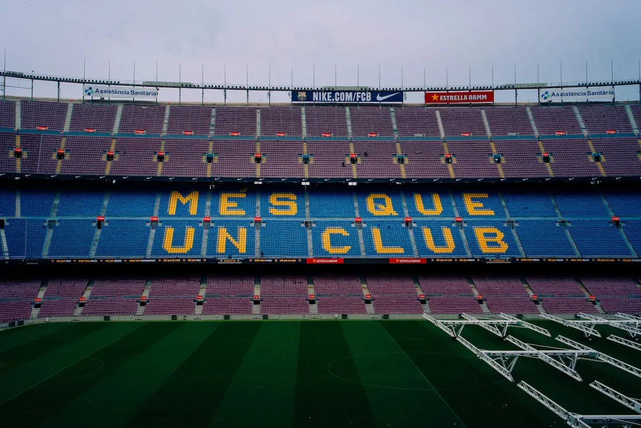 Trybuny Camp Nou z napisem "Més que un club" w żółtych literach, symbolizującym hymn Barcelony.