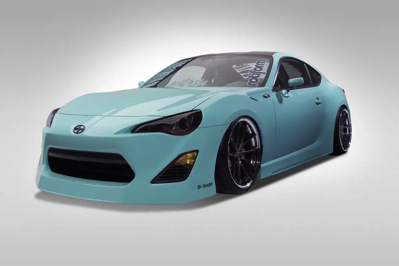 Turkusowy Scion FR-S z przyciemnionymi światłami i czarnymi felgami, gotowy do jazdy.