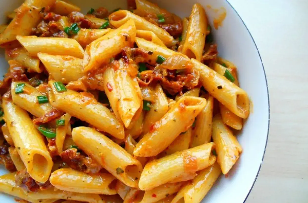 Penne z sosem z suszonych pomidorów, czosnku i ziół, posypane szczypiorkiem. Pyszne danie, które zachwyci każdego miłośnika makaronu.