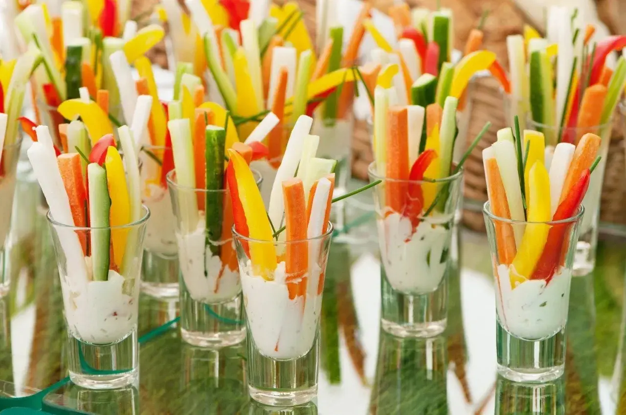 Kolorowe warzywa pokrojone w słupki, podane w kieliszkach z dipem. Idealne finger food opakowania na przyjęcie.