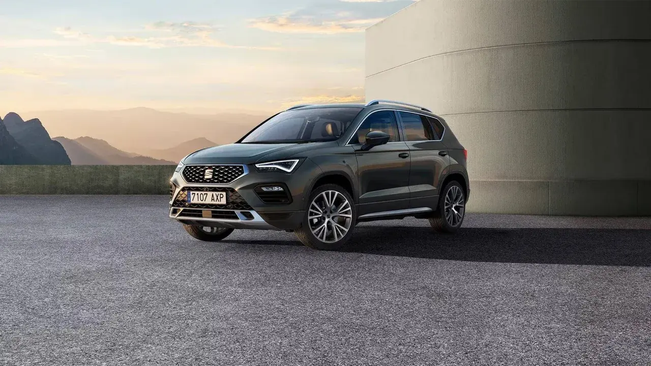 SUV Seat Ateca, con le sue dimensioni perfette per ogni avventura, parcheggiato all'esterno con un paesaggio montano sullo sfondo.