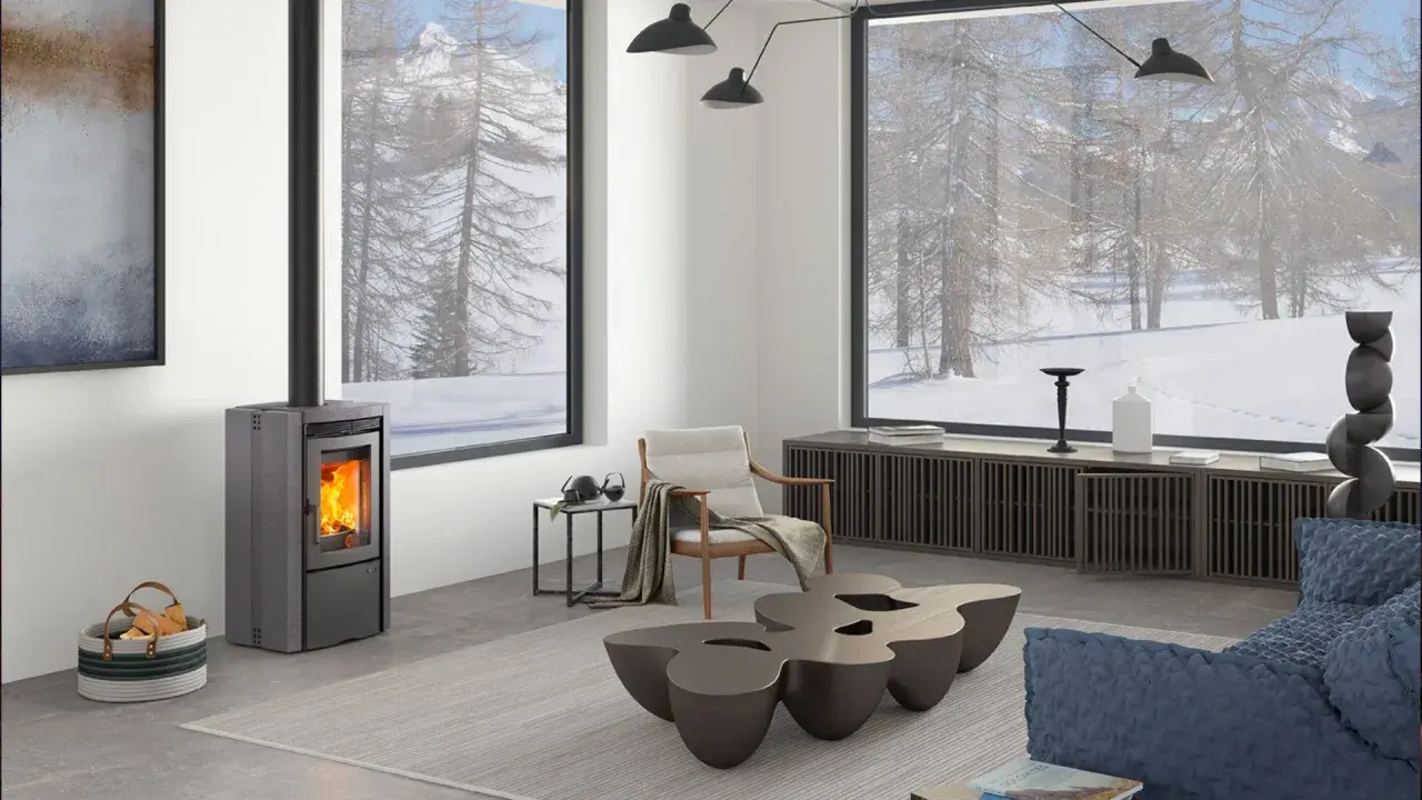 Estufa de pellets moderna en un salón acogedor con vistas nevadas. ¿Qué tipo de estufa es mejor para crear este ambiente cálido?