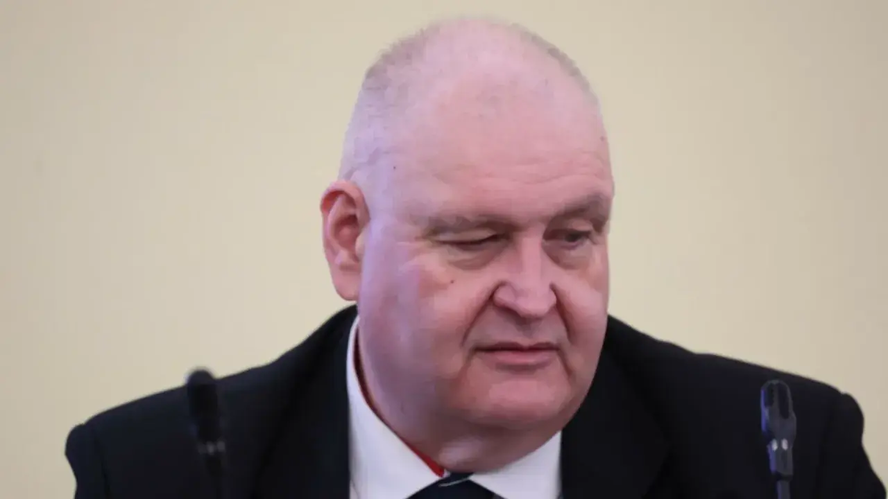 Jan Kowalski, syn Wacława Kowalskiego, w garniturze, z mikrofonem przed sobą.