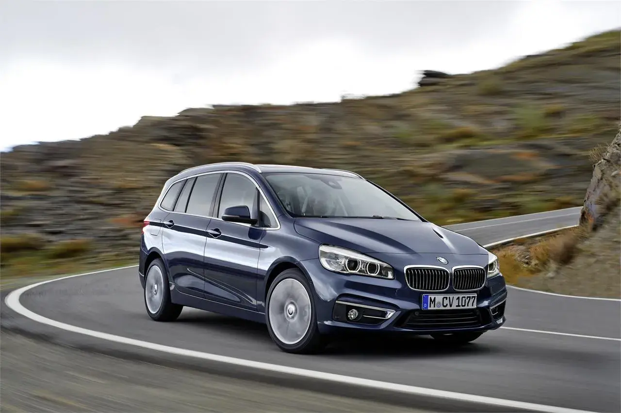 Un BMW Serie 2 Gran Tourer azul oscuro en una carretera sinuosa. A pesar de su diseño, algunos propietarios han reportado problemas.
