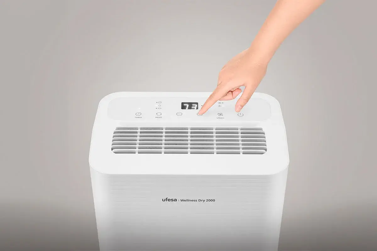 Mano ajustando el control de un deshumidificador Ufesa Wellness Dry 2000. Este deshumidificador sirve para controlar la humedad del ambiente.