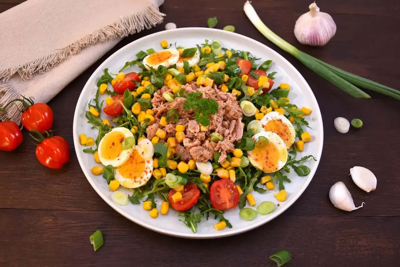 Bunter Thunfischsalat mit Eiern, Mais und Tomaten, garniert mit Frühlingszwiebeln. Ein leichter und gesunder Thunfischsalat.