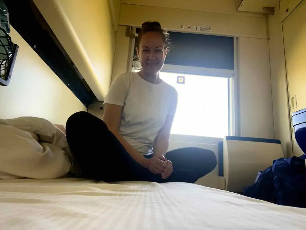 Frau im Bett eines Nachtzugs nach Krakau, bereit für die Reise.