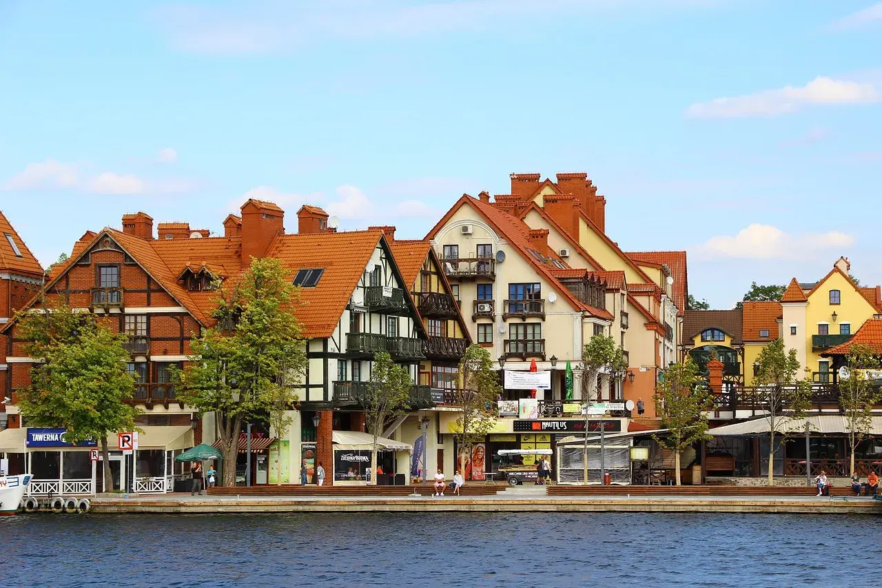 Urokliwa nadmorska promenada z kolorowymi kamieniczkami, jak z bajki o Mikołajkach w Warszawie.