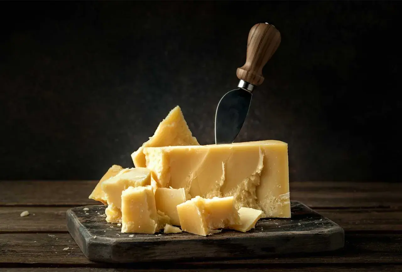 Un pezzo di Grana Padano, pronto per essere gustato, sembra quasi in attesa, come un tesoro in gravidanza.