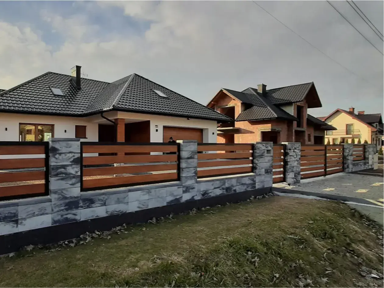 Nowoczesne ogrodzenia domów z kamienia i drewna, otaczające biały i budowany dom.