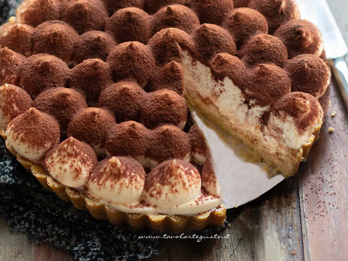 Una deliziosa torta tiramisù, con ciuffi di crema e cacao, pronta per essere gustata.