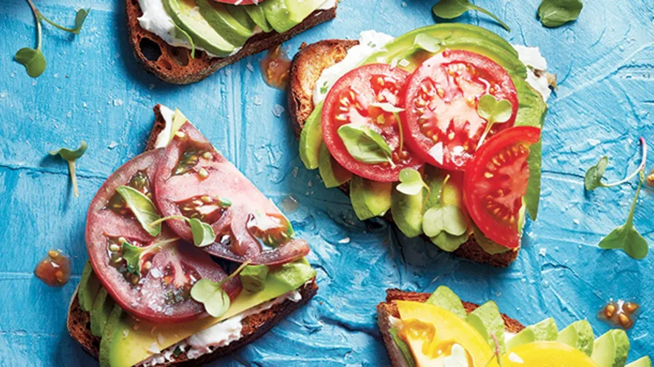 Tartines gourmandes : une recette avocat simple et savoureuse avec tomates fraîches et pousses croquantes sur pain grillé.