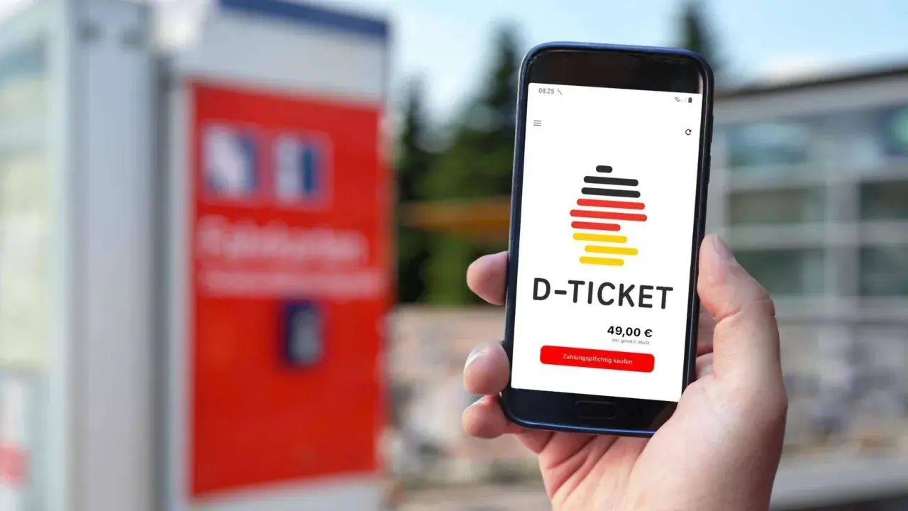 Smartphone zeigt D-Ticket App mit Preis und Kaufbutton. Verschiedene Deutschlandticket zahlungsarten sind möglich.