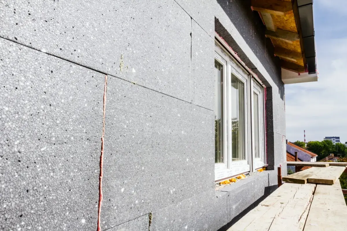 Panneau de polystyrène gris pour isolation exterieur finition. Fenêtre blanche installée. Chantier en cours.