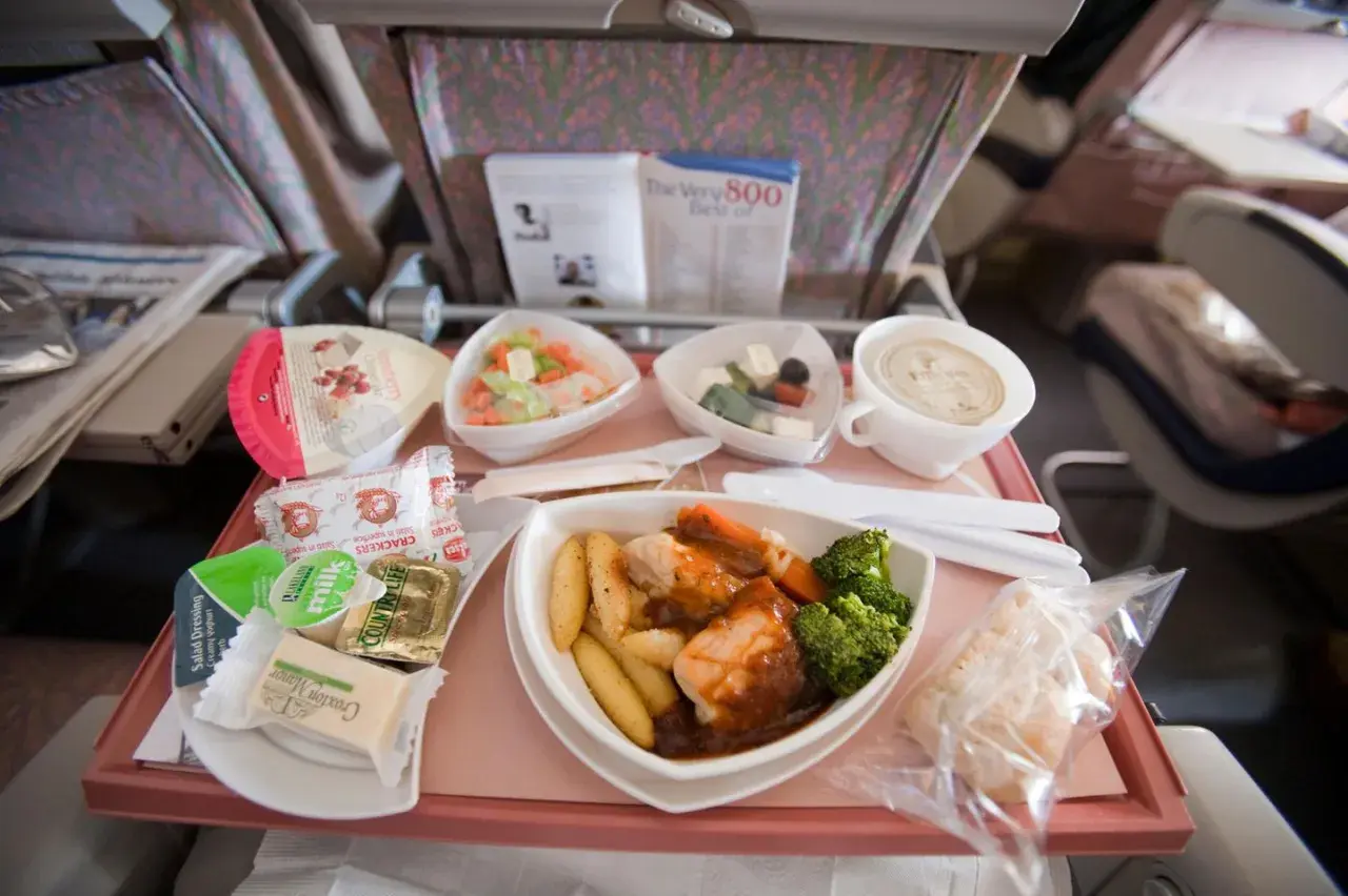 Ein Flugzeugessen mit Hähnchen, Kartoffeln, Brokkoli, Salat und einem Dessert. Guten Appetit beim Essen im Flugzeug!