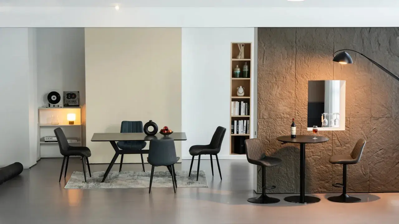 Salle à manger moderne avec chaises en cuir synthétique, table et coin bar.