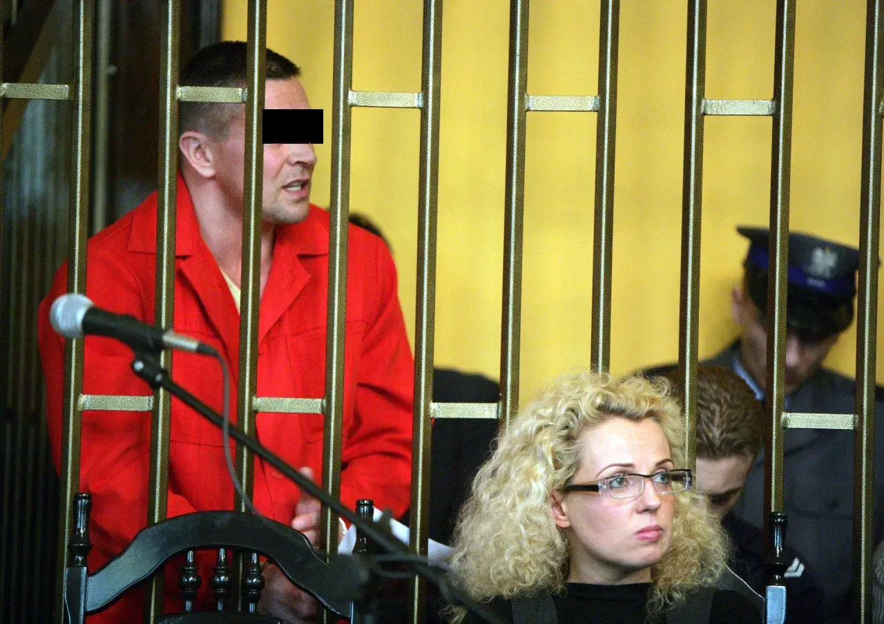 Mężczyzna w czerwonym ubraniu, przypominający lelek gangster, za kratami. Obok kobieta w okularach i policjant.