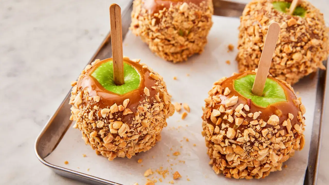 Manzanas acarameladas cubiertas de cacahuetes, perfectas para recetas con manzanas.