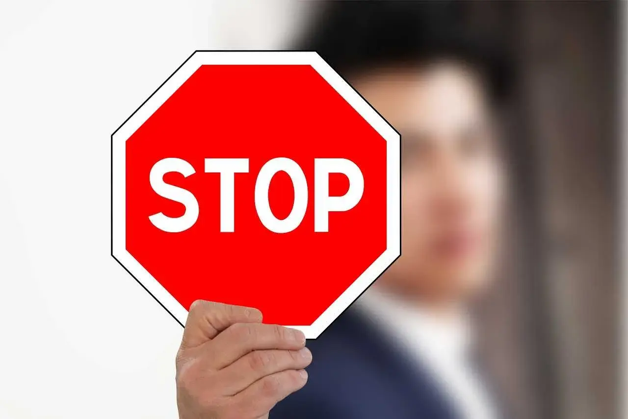 Mężczyzna trzyma czerwony znak stop.