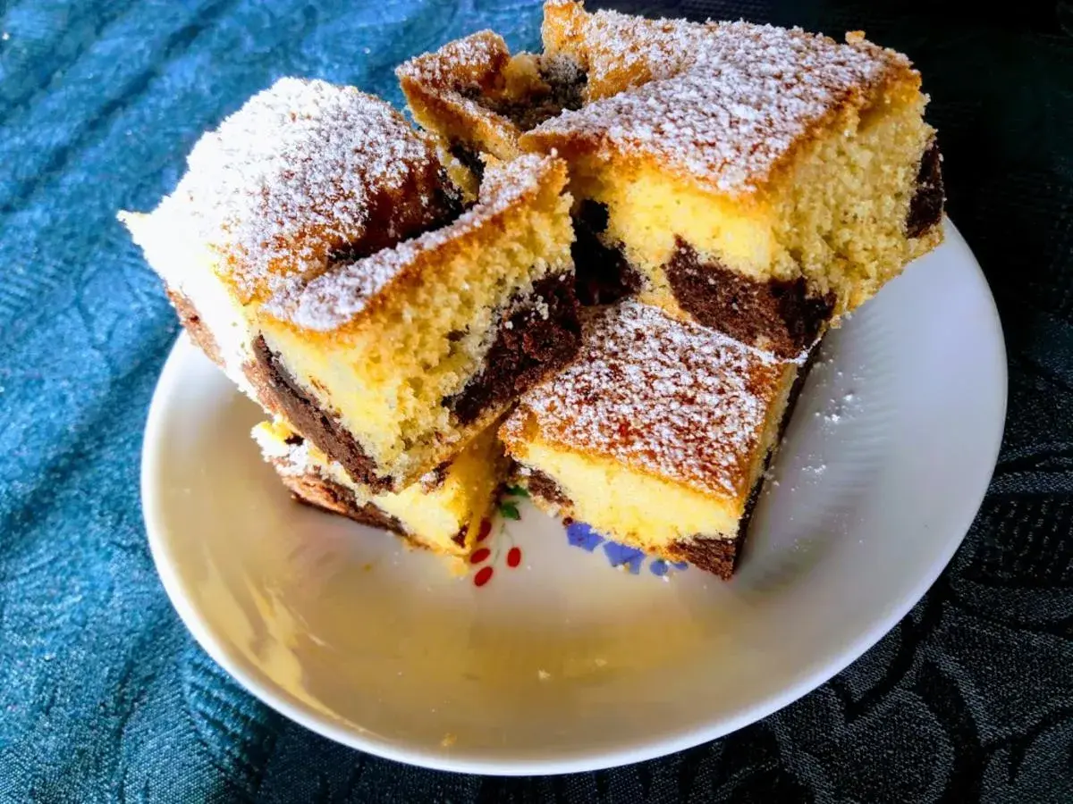 Saftige Kuchenstücke mit Marmormuster, bestäubt mit Puderzucker. Ein köstlicher, versunkener Streuselkuchen, der zum Genießen einlädt.