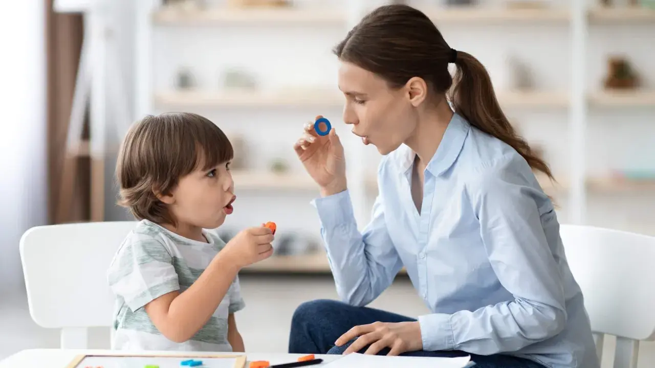 Terapeuta enseña trabalenguas para niños usando piezas de letras.