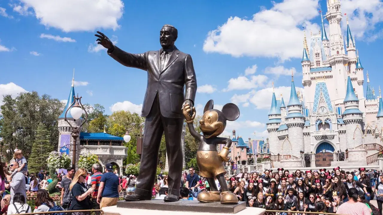 Walt Disney i Myszka Miki pozdrawiają tłumy przed zamkiem w największym Disneylandzie na świecie.