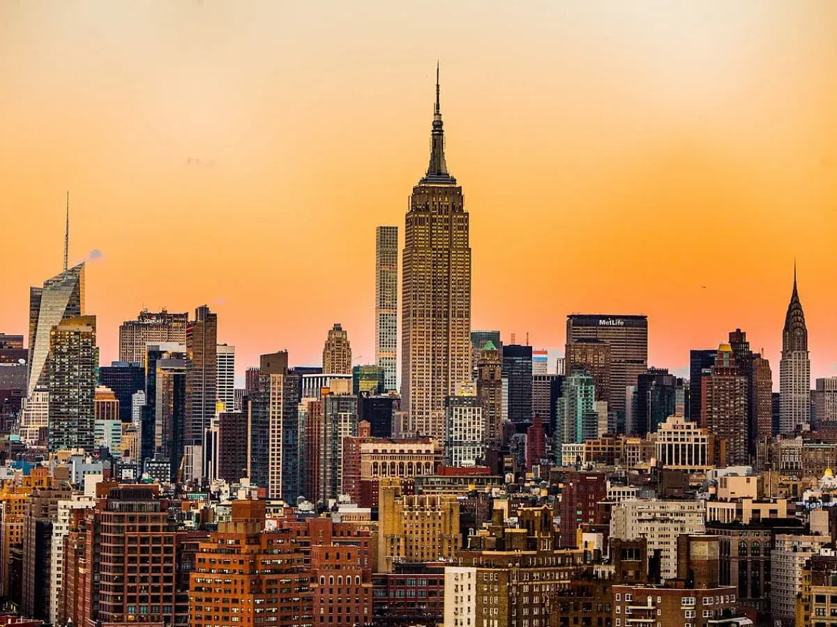 Widok na panoramę Nowego Jorku z Empire State Building w zachodzącym słońcu.