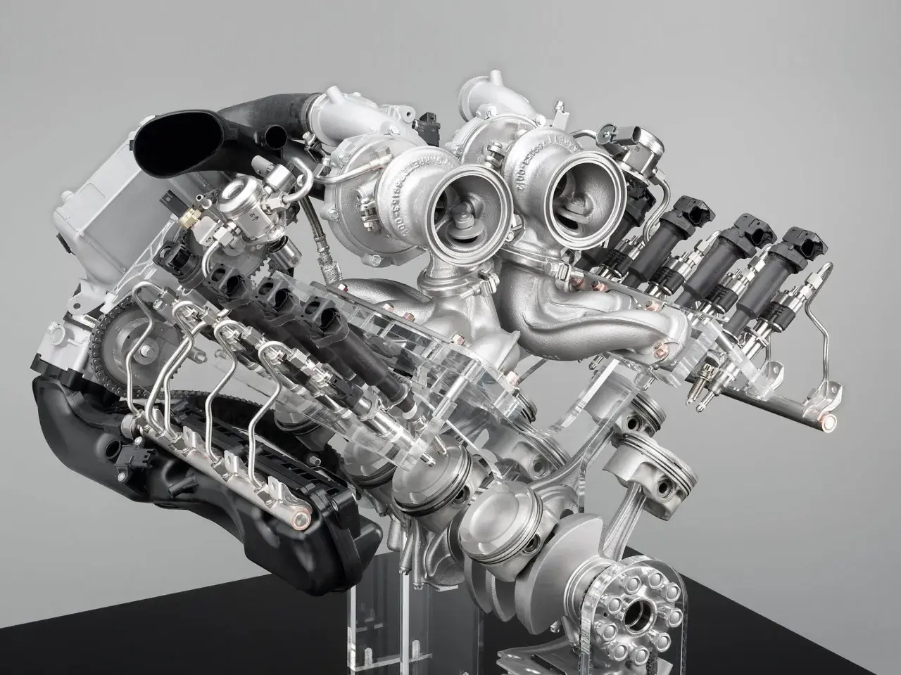 Detaljerad vy av en BMW V8-motor med dubbelturbo. Synliga kolvar, vevaxel och insprutningssystem.
