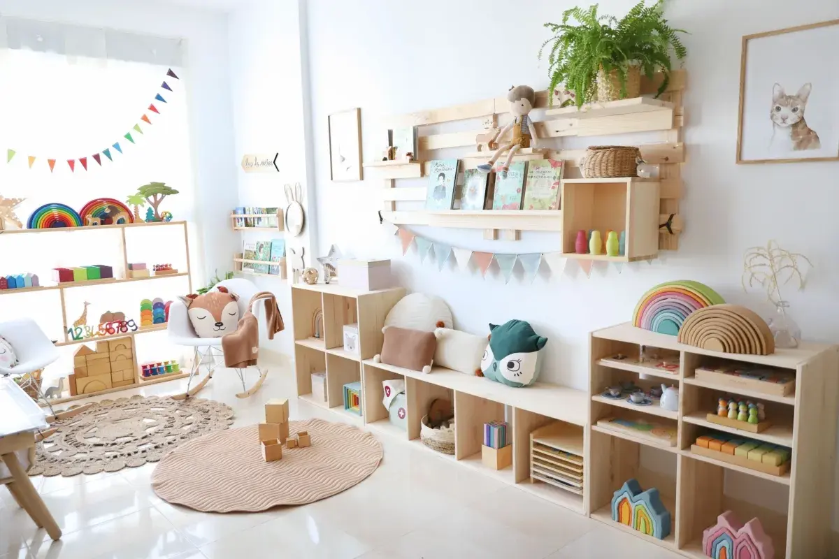Una acogedora zona de juegos para niños, llena de juguetes de madera, libros y peluches, invita a la imaginación y al aprendizaje.