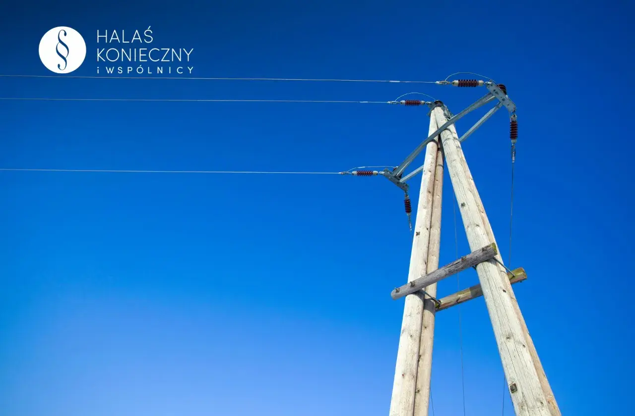 Drewniany słup energetyczny na tle błękitnego nieba. Zastanawiasz się, ile za słup energetyczny na działce?