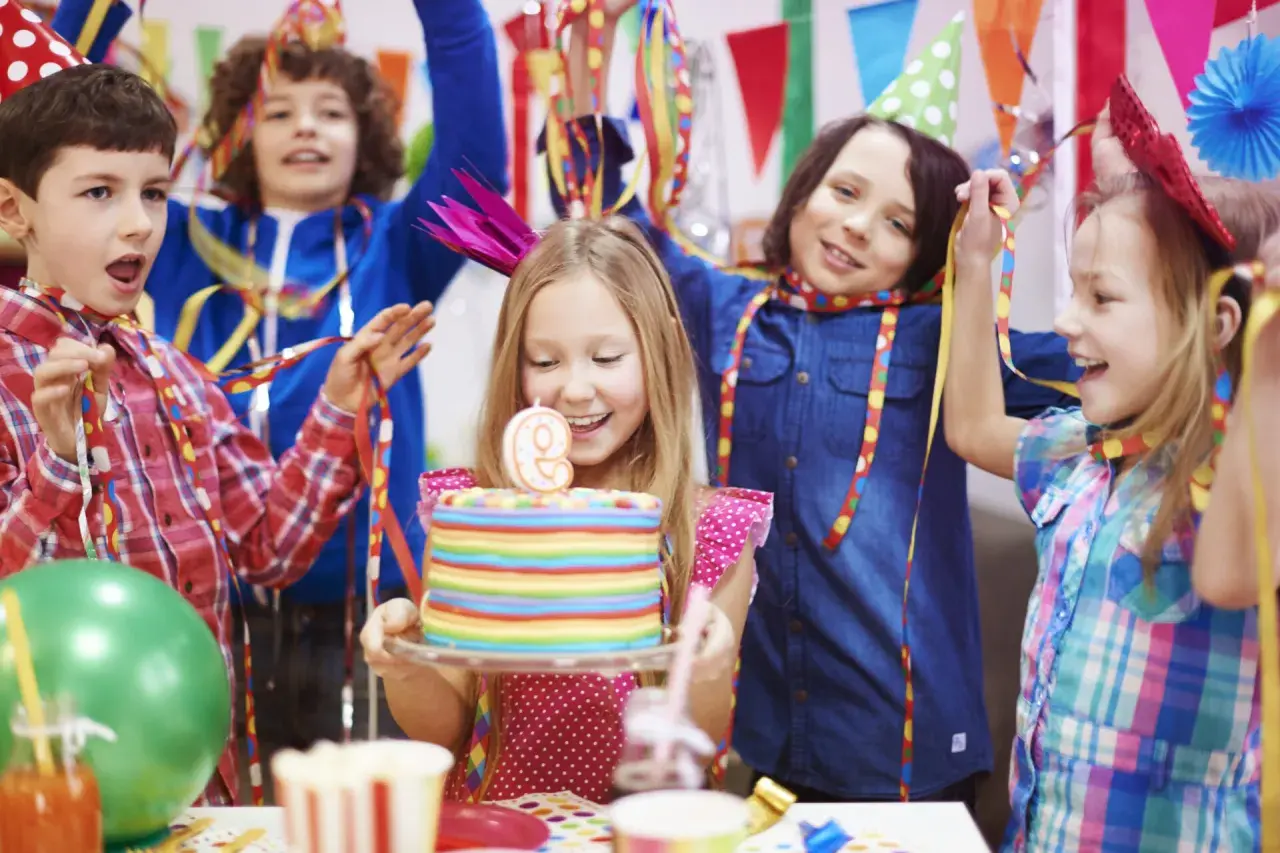 Niños celebrando un cumpleaños con pastel y globos. ¡Muchas actividades divertidas para niños!