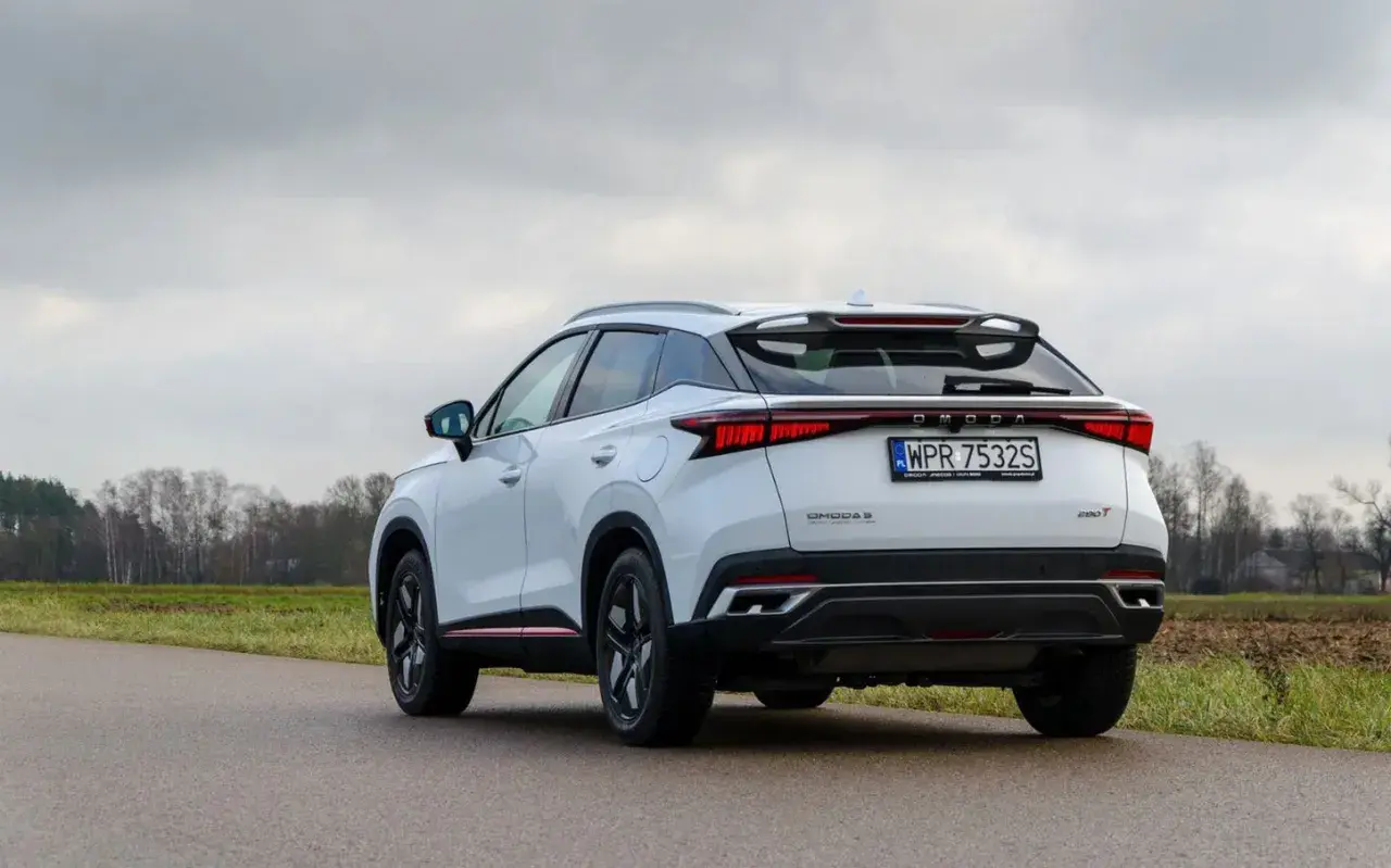 Biały, nowoczesny SUV OMODA S z charakterystycznym pasem świateł z tyłu. To jeden z nowych chińskich samochodów, który zyskuje popularność.