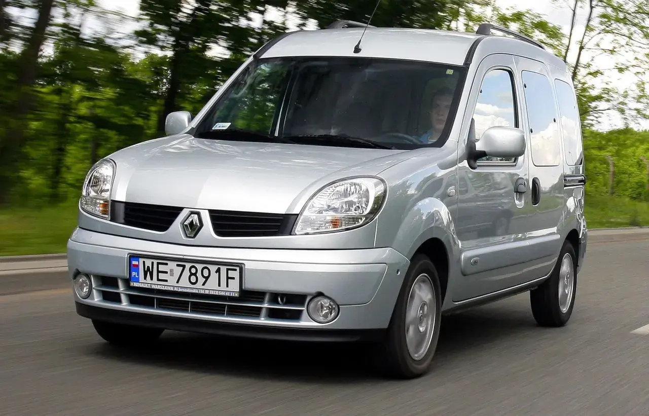 Srebrny Renault Kangoo 1.5 dCi jedzie po drodze wśród zieleni.