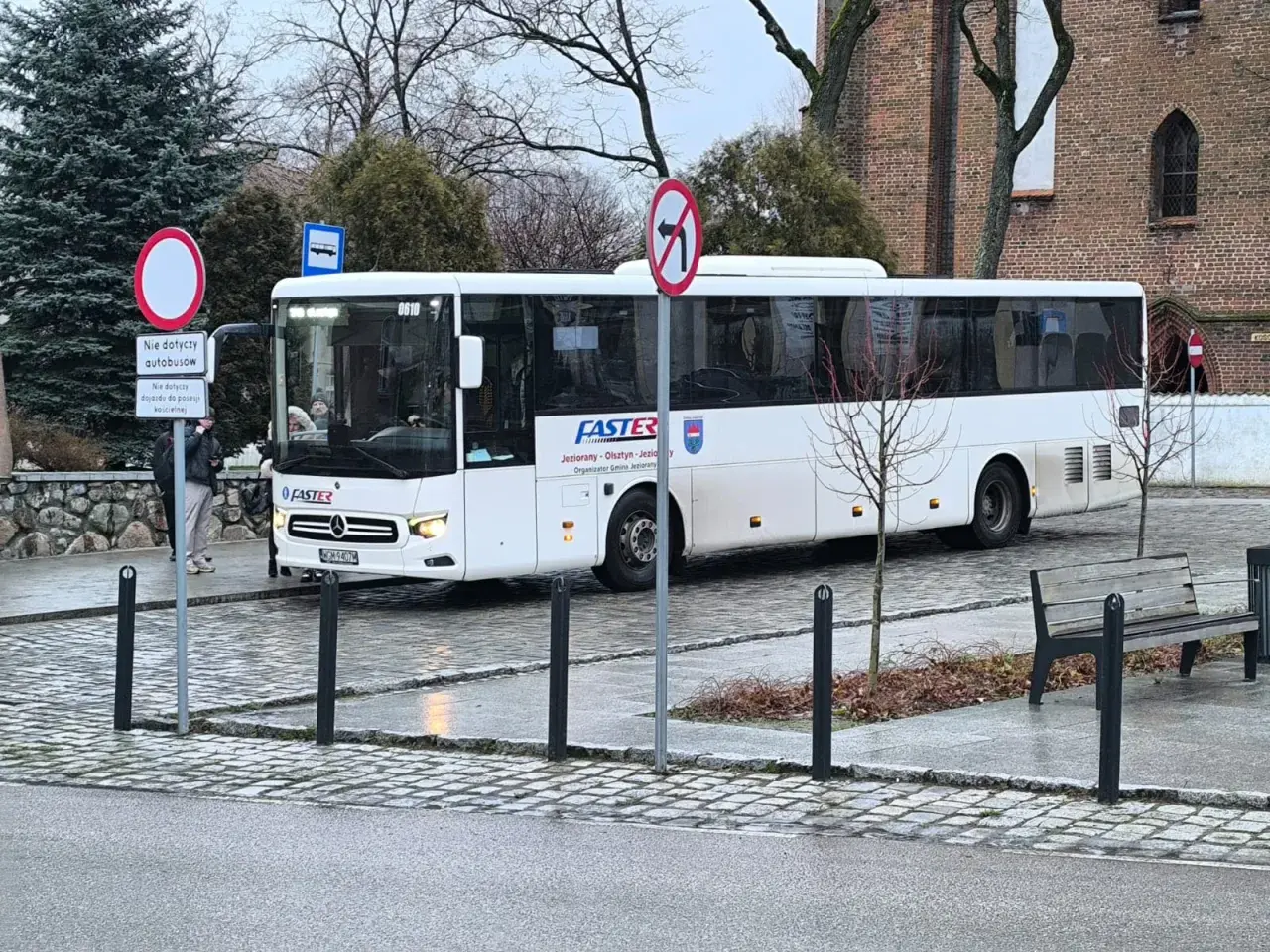 Biały autobus FASTER z Olsztyna, gotowy do kursu. Może właśnie jedzie po bilet miesięczny dla pasażerów.