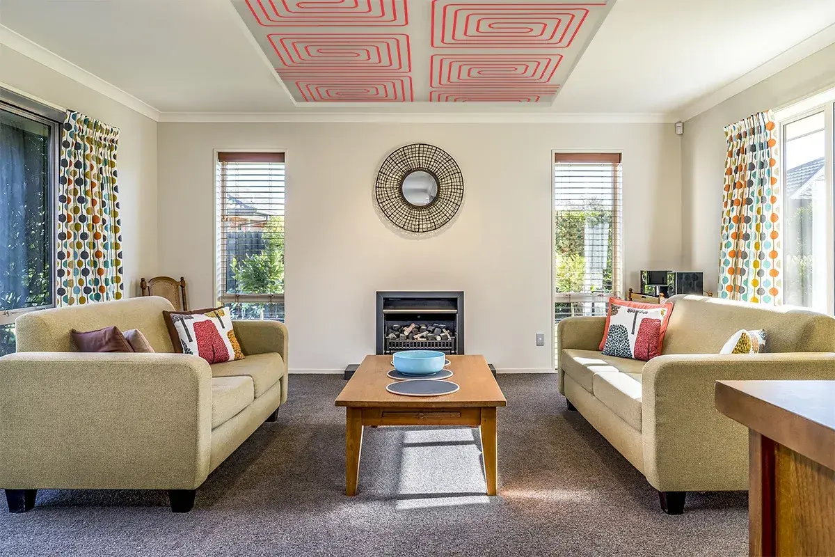 Salón acogedor con sofás, chimenea y un innovador techo radiante que calienta el ambiente.