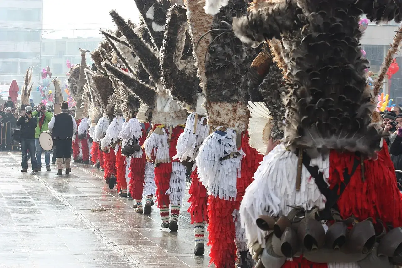 Un corteo di kukeri bulgari in costumi elaborati con piume e campanelli, pronti a scacciare il male.