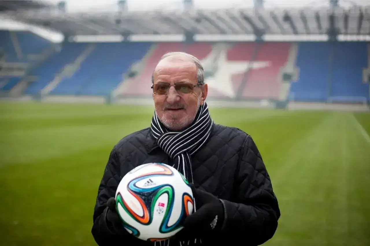 Wojciech Kwiecień, z piłką w rękach, na tle stadionu. Jego majątek to lata pracy i pasji do futbolu.