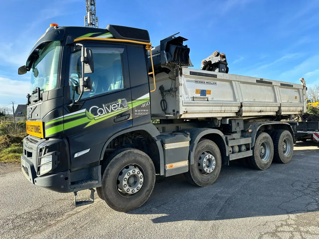 Camion benne de chantier avec inscription "Calvez" et "Poids cabine camion" sur le pare-chocs. Le véhicule est prêt à transporter des matériaux.