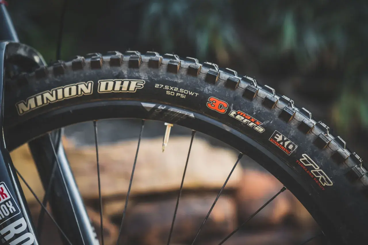 Close-up of a Maxxis Minion DHF tire, 27.5x2.50WT, 50 PSI, EXO Protection, TR. Ready for any trail, unlike the DHR.