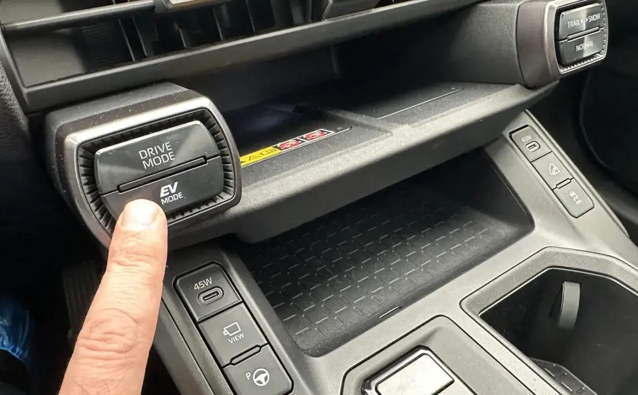Palec naciska przycisk EV MODE na panelu Toyota. Dowiedz się, co to drive mode Toyota i jak wpływa na jazdę.