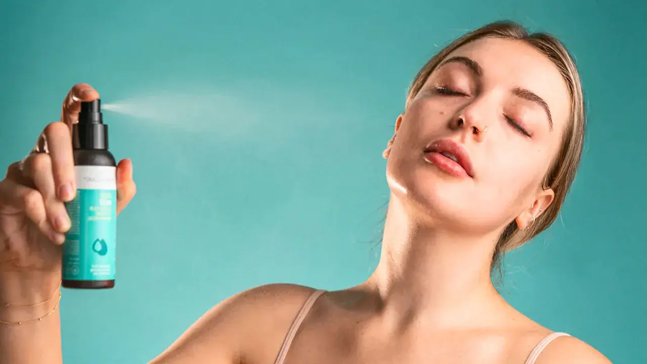 Une femme reçoit une brume rafraîchissante sur le visage. Une brume sert à hydrater et revitaliser la peau.