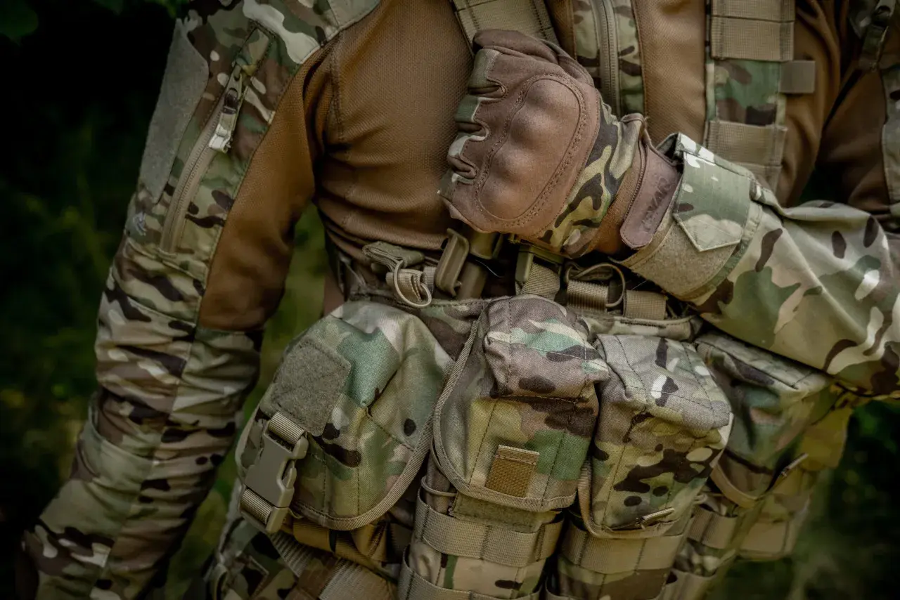 Żołnierz w mundurze w kamuflażu multicam, z rękawicami i kamizelką taktyczną. Materiał to wytrzymała cordura 500 czy 1000?