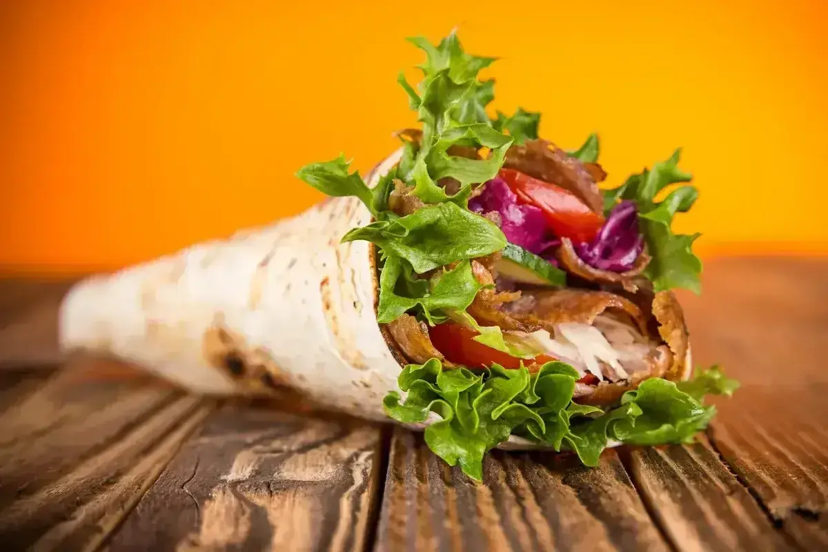 Pyszny kebab w tortilli, pełen mięsa, warzyw i sosu. Idealny na szybki posiłek, choć warto pamiętać o jego tortilla kcal.