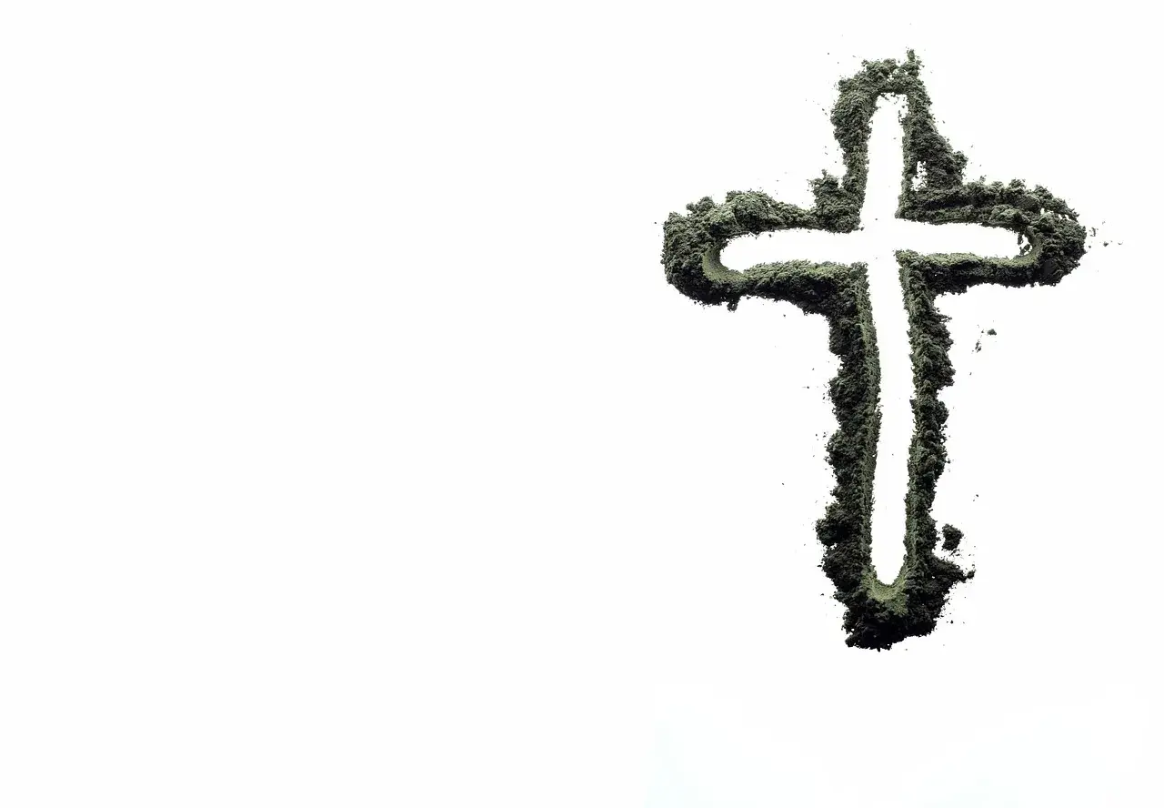 Krzyż z zielonego proszku, symbolizujący życie i wiarę, na tle pustki. Czy inseminacja może być zgodna z naukami kościoła?