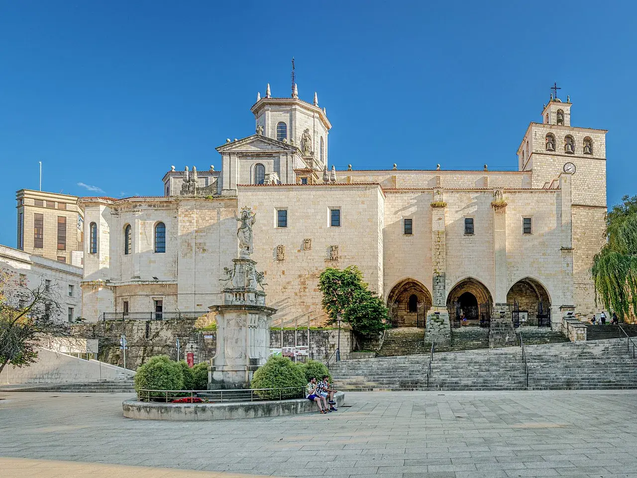 La imponente catedral de Santander se alza majestuosa bajo un cielo azul, con su fachada de piedra iluminada por el sol.