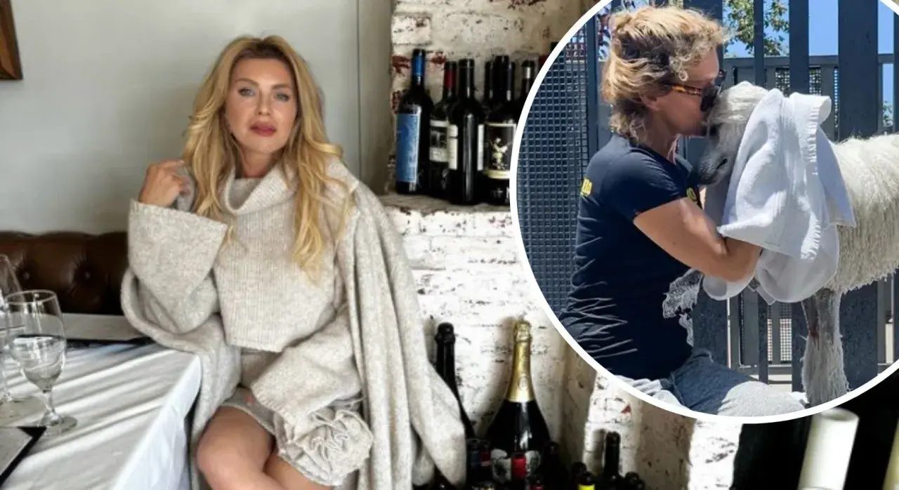 Eva Halina Rich w swetrze siedzi przy stole, a obok niej wesoło przytula białego zwierzaka.
