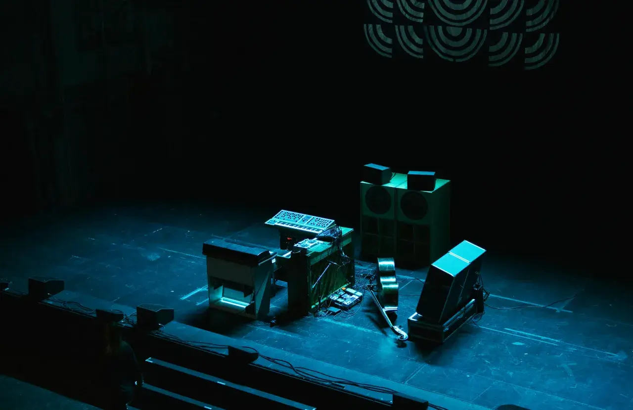 Scen för jazzfestival med synthesizers, högtalare och en fiol.