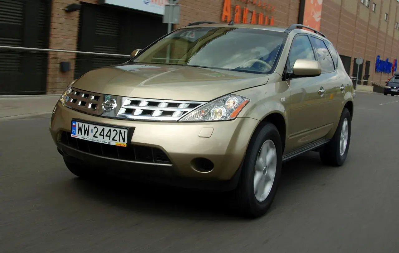Złoty Nissan Murano 3.5 V6 w ruchu miejskim, z widocznym numerem rejestracyjnym WW 2442N.